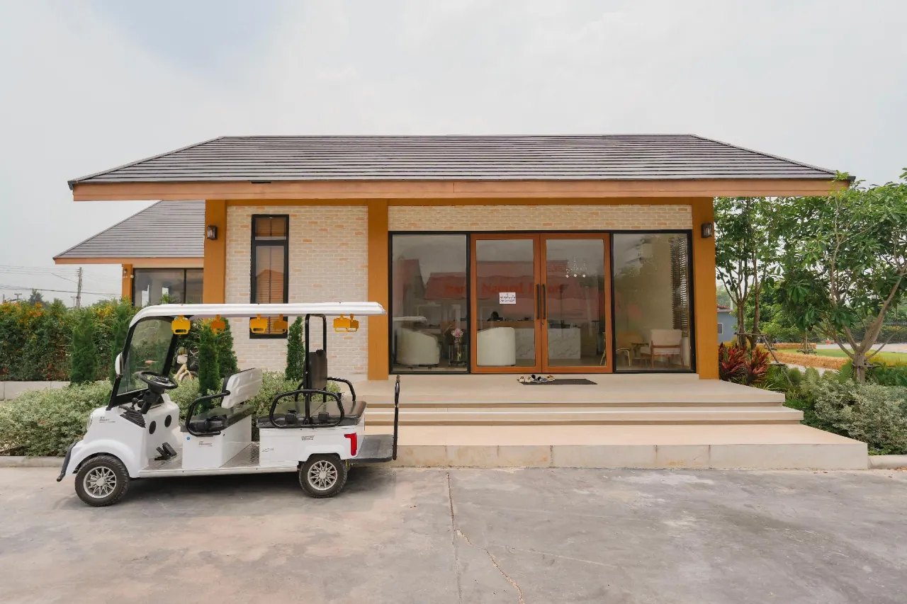 Cream-brick reception building with orange trim and a resort golf cart