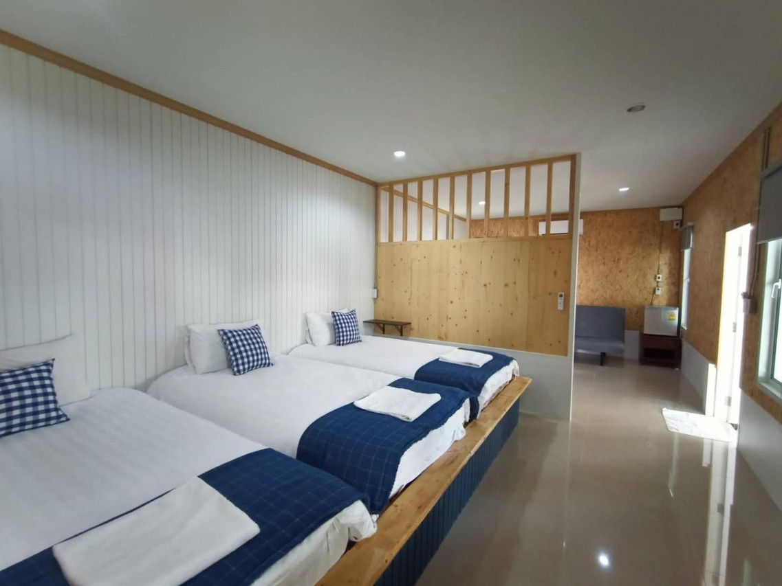 Family room with several single beds in white and navy at Lamoon Boutique Hotel