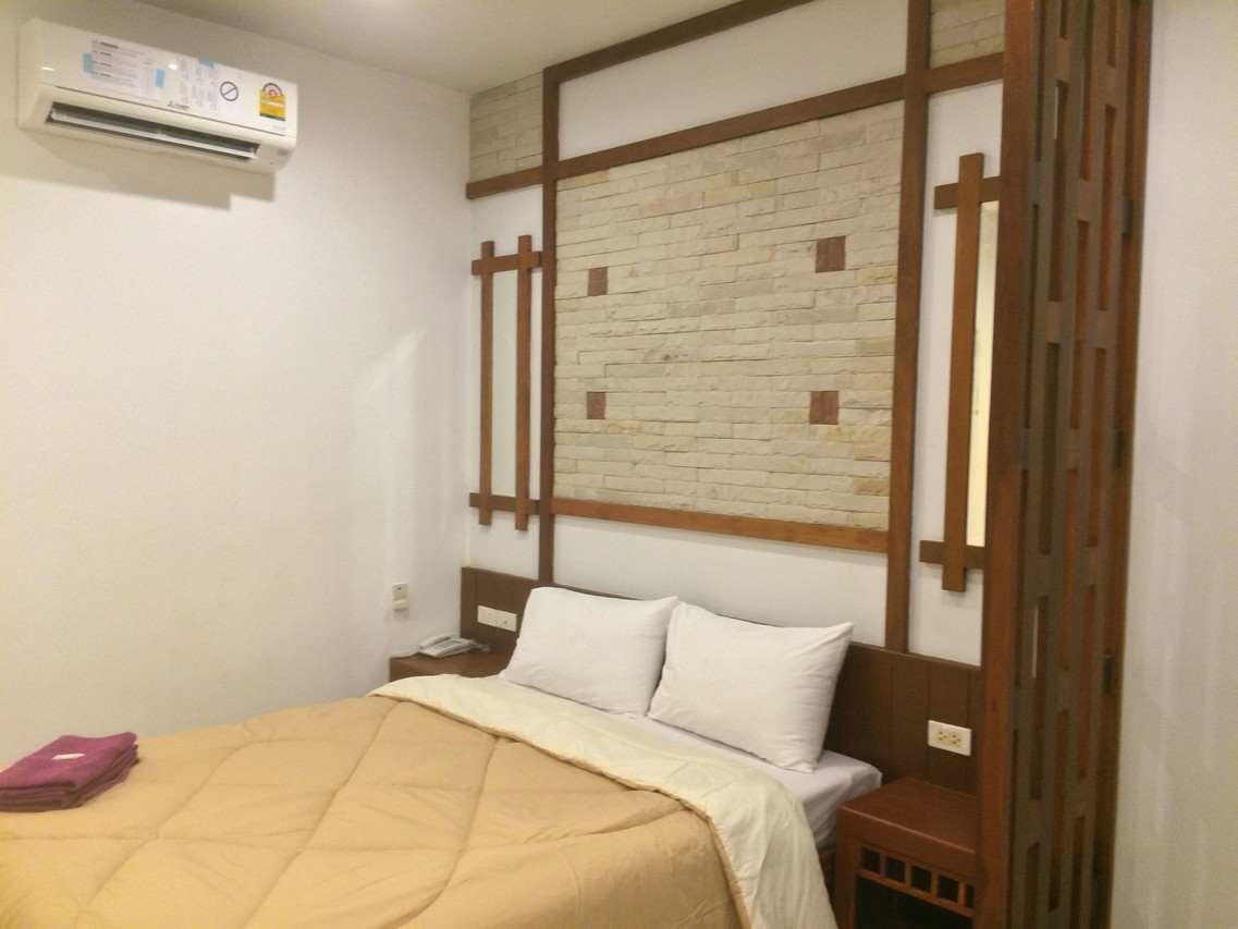 Suanrak Resort guest room with double bed, stone feature wall and air-conditioning