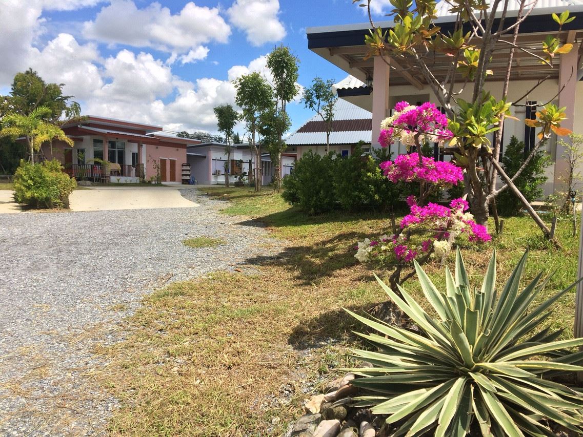 Standalone garden bungalow with bougainvillea and a gravel path