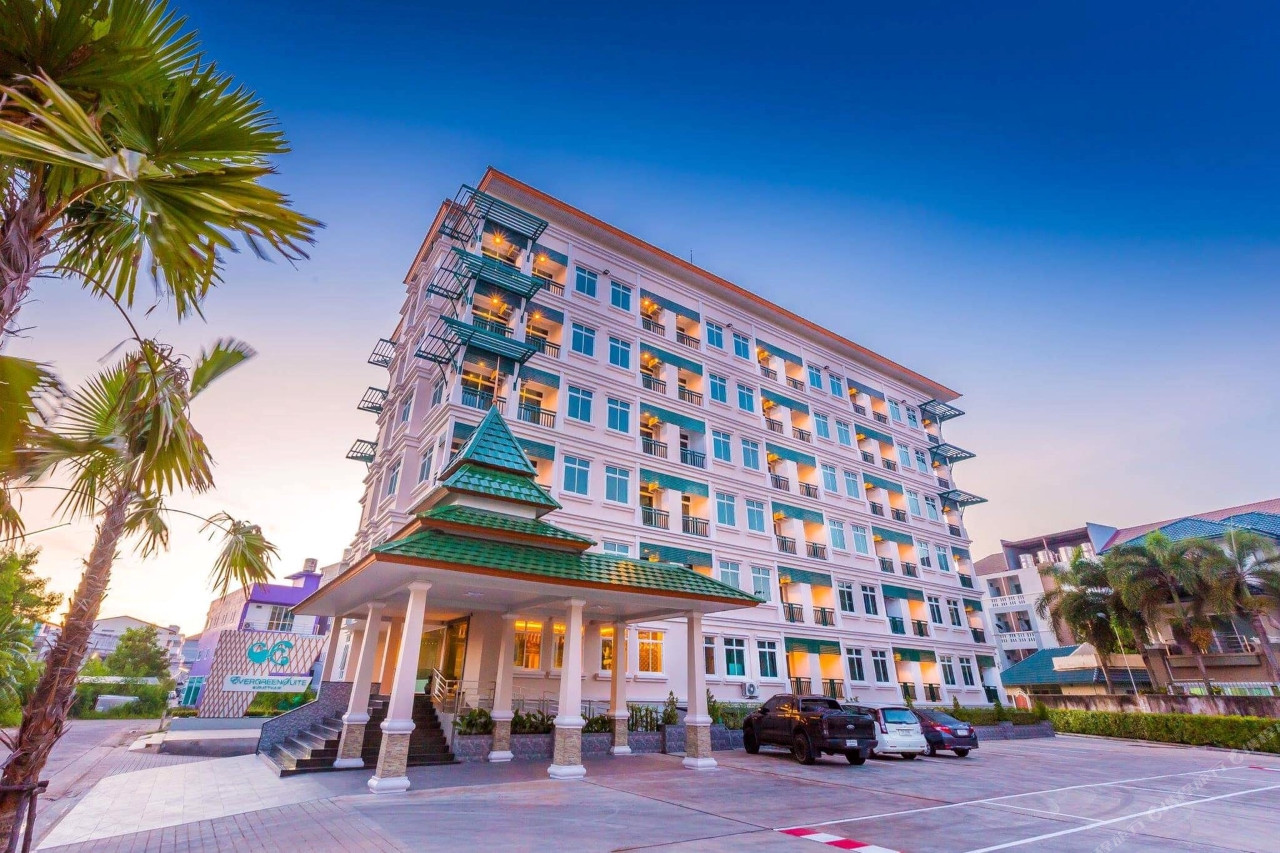 อาคาร Evergreen Suite Hotel มุมหน้าพร้อมซุ้มทางเข้าหลังคาทรงไทยยามเย็น