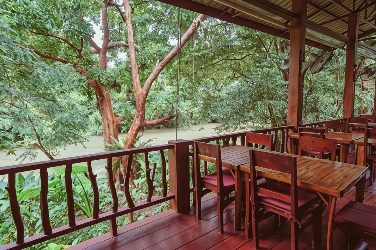 Open-air wooden restaurant deck over the river at Khao Sok Riverside Cottages