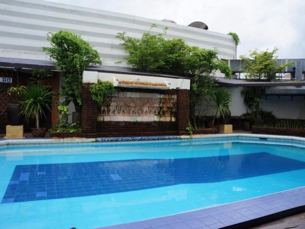 สระว่ายน้ำกลางแจ้ง Petchkasem Grand Hotel กับกำแพงน้ำตกลายช้าง