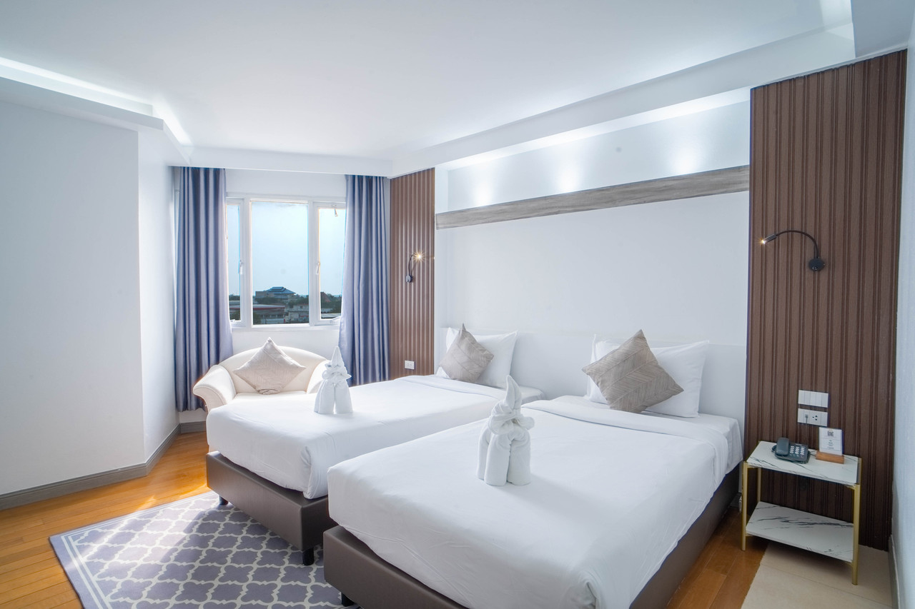 ห้อง Deluxe เตียงคู่ของ Thong Tarin Hotel ผนังไม้ลายตั้ง วิวเมืองสุรินทร์
