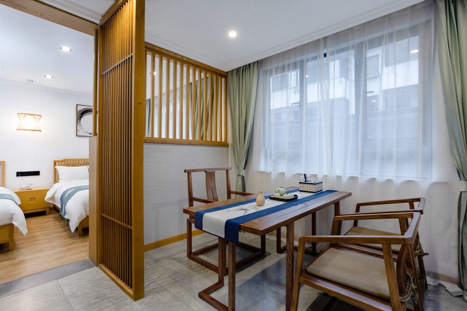 ห้องพักของ Yunlan Inn มีฉากไม้กั้น อ่างอาบน้ำลอย และผ้าขนหนูปักชื่ออินน์