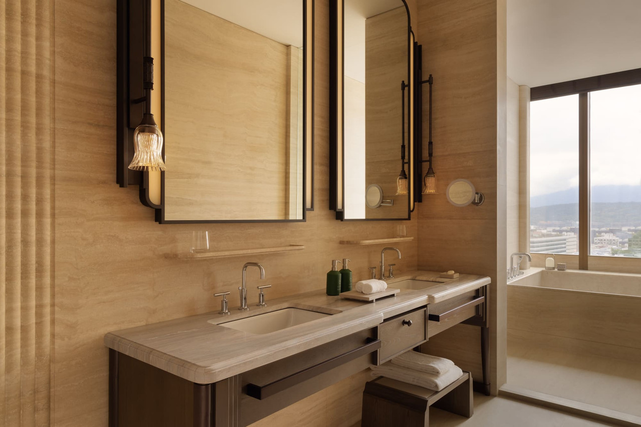 Guest room at Capella Taipei with city views and travertine stone bathroom