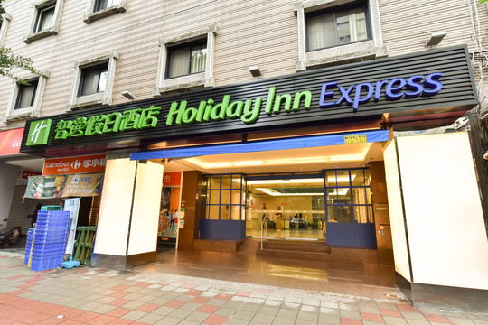 ทางเข้าโรงแรม Holiday Inn Express Taipei Train Station ป้ายสัญลักษณ์ IHG ชัดเจน