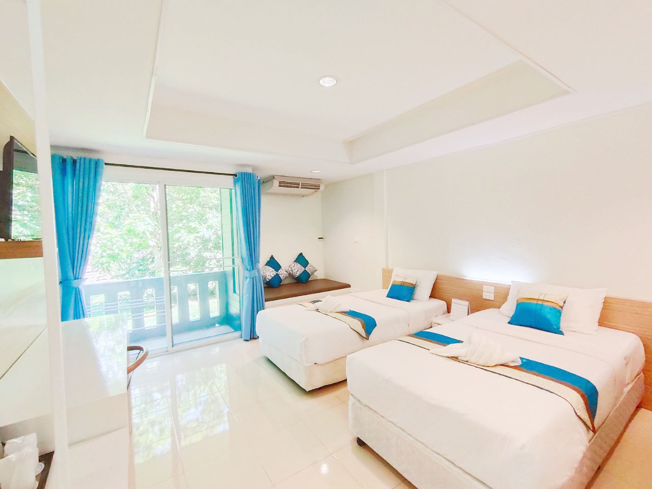 ห้องพักบ้านหงษ์หยกตกแต่งโทนสว่าง มีระเบียงและโซฟา