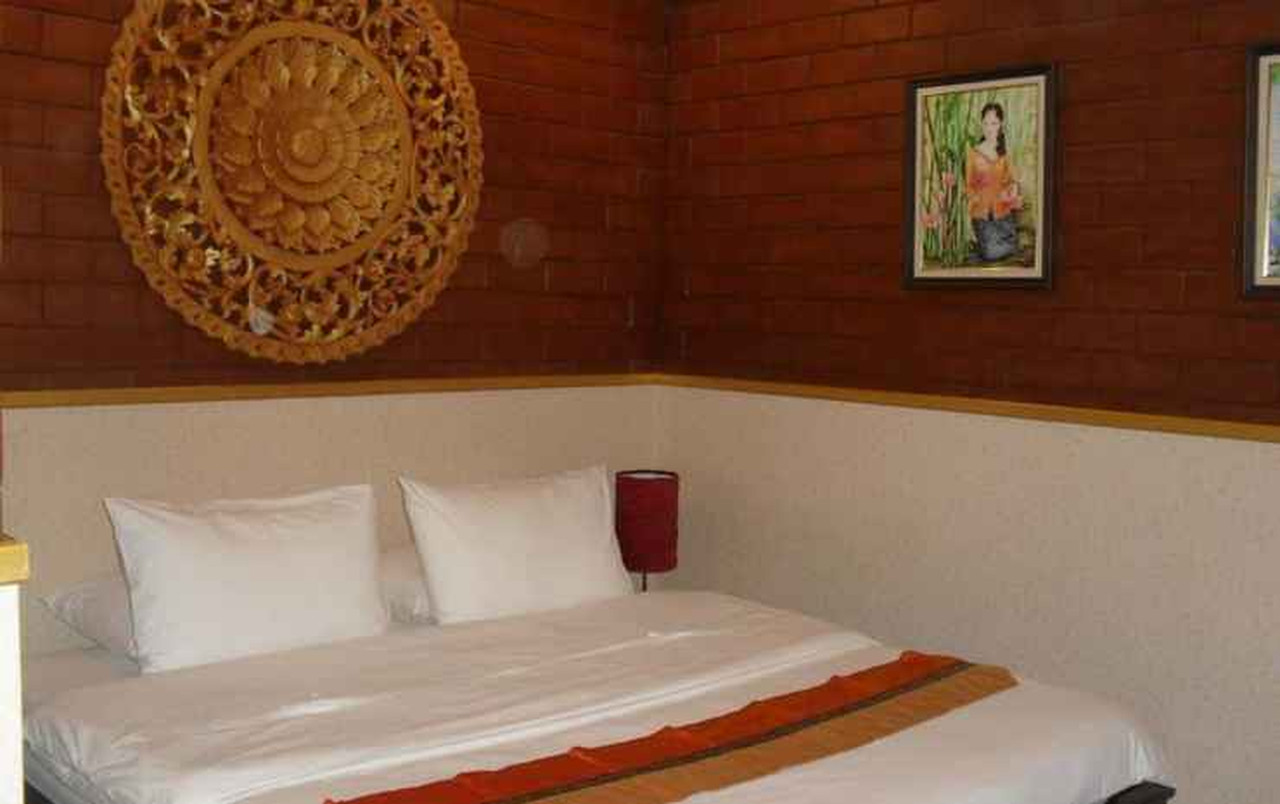 Bed beneath a large round gilded hand-carved wood panel above the headboard