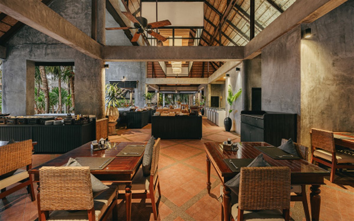 Beachfront restaurant in raw concrete and timber with a high open ceiling