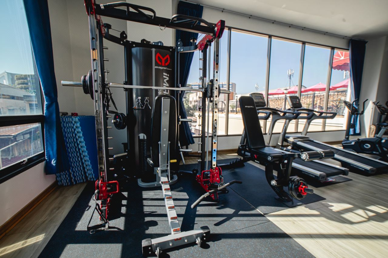 Fitness room at Banbua Grand Udon with large windows over the city