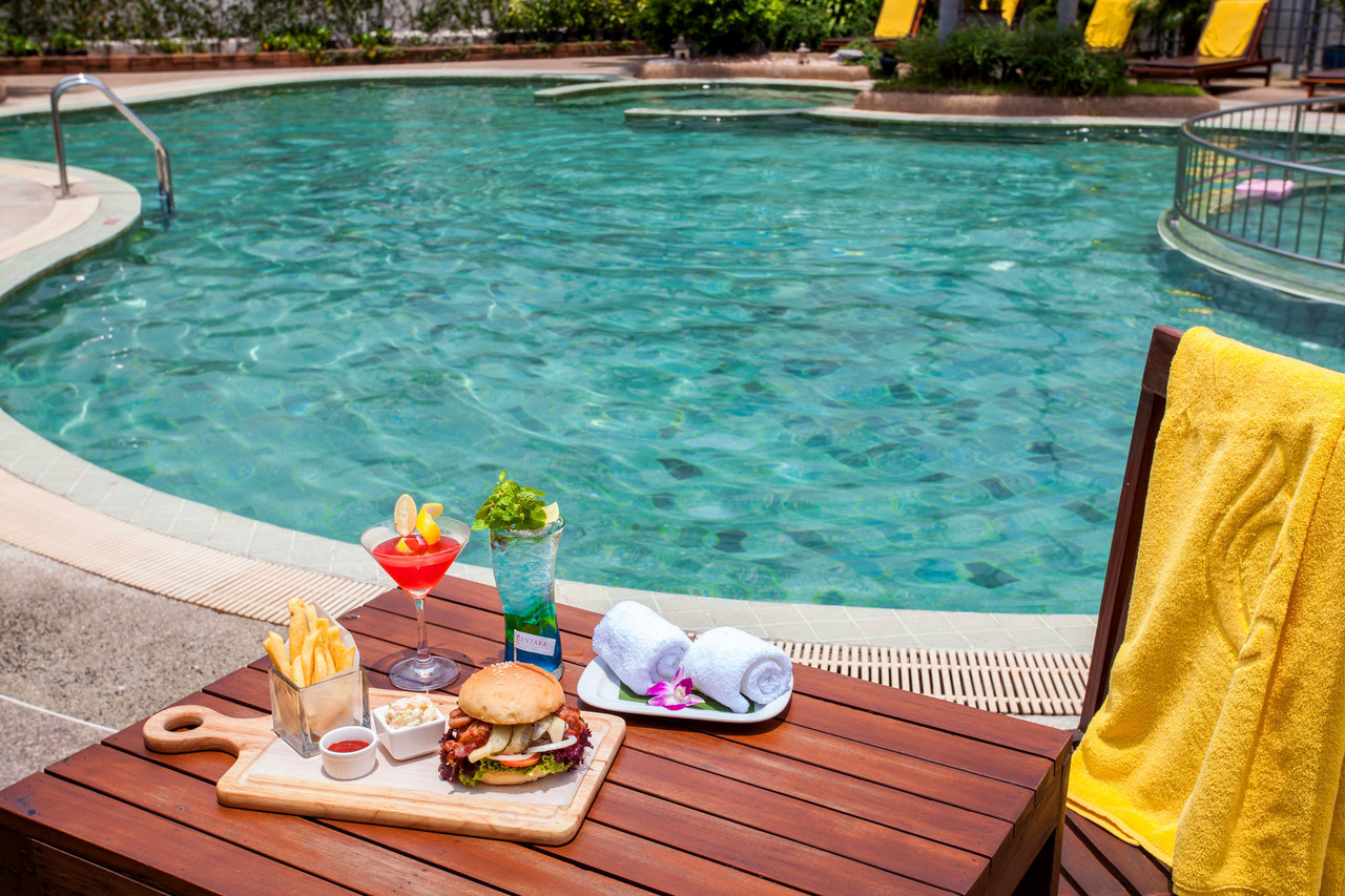 Outdoor swimming pool with sun loungers at Centara Udon Thani