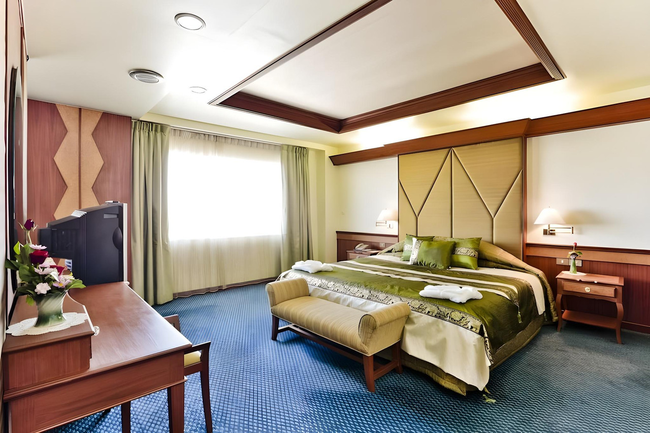 Suite room at Charoen Hotel Udonthani with green tones and blue carpet