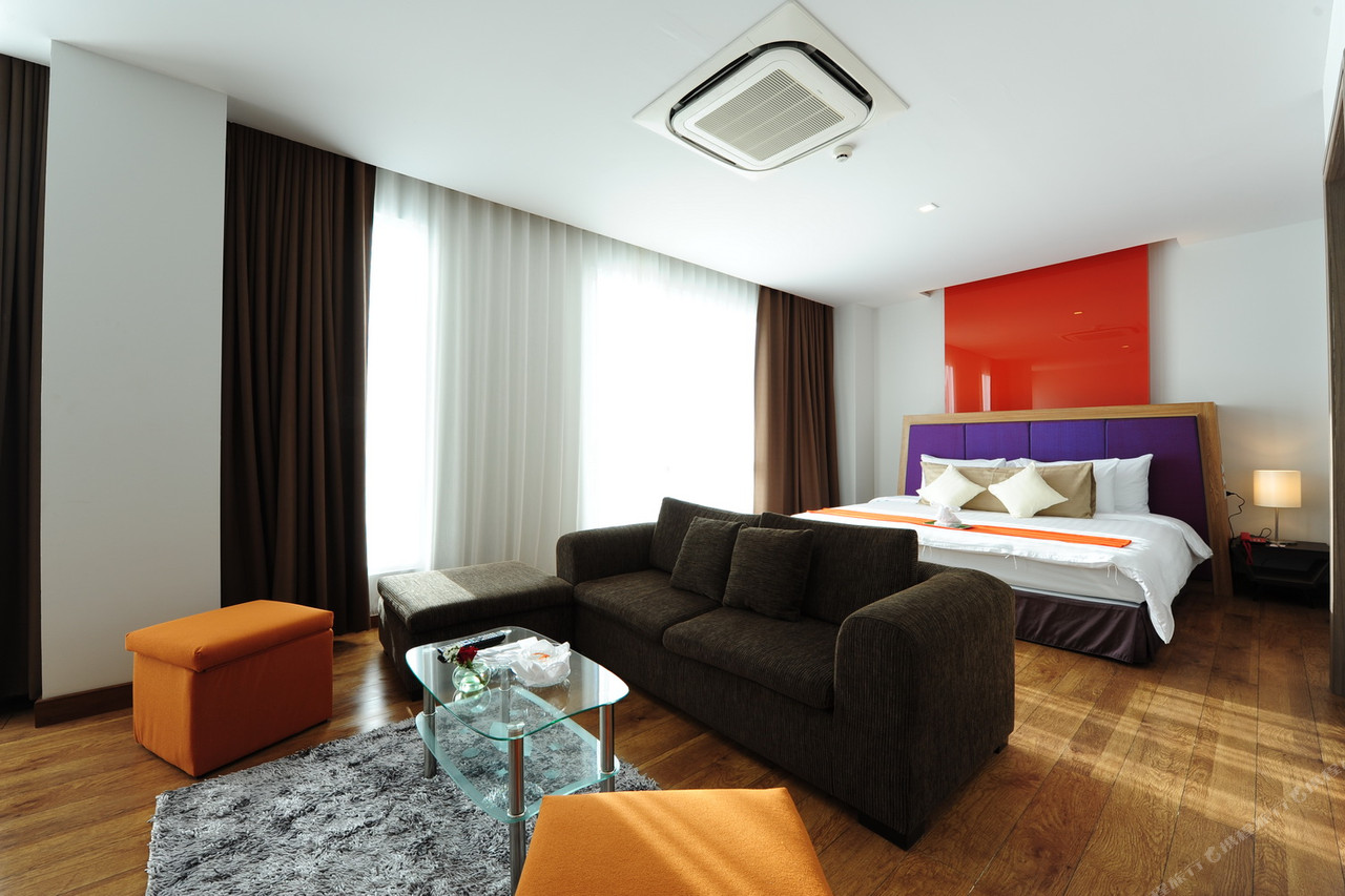 ห้อง Design Suite ผนังส้ม หัวเตียงม่วง พื้นไม้ ที่ Prajaktra Design Hotel