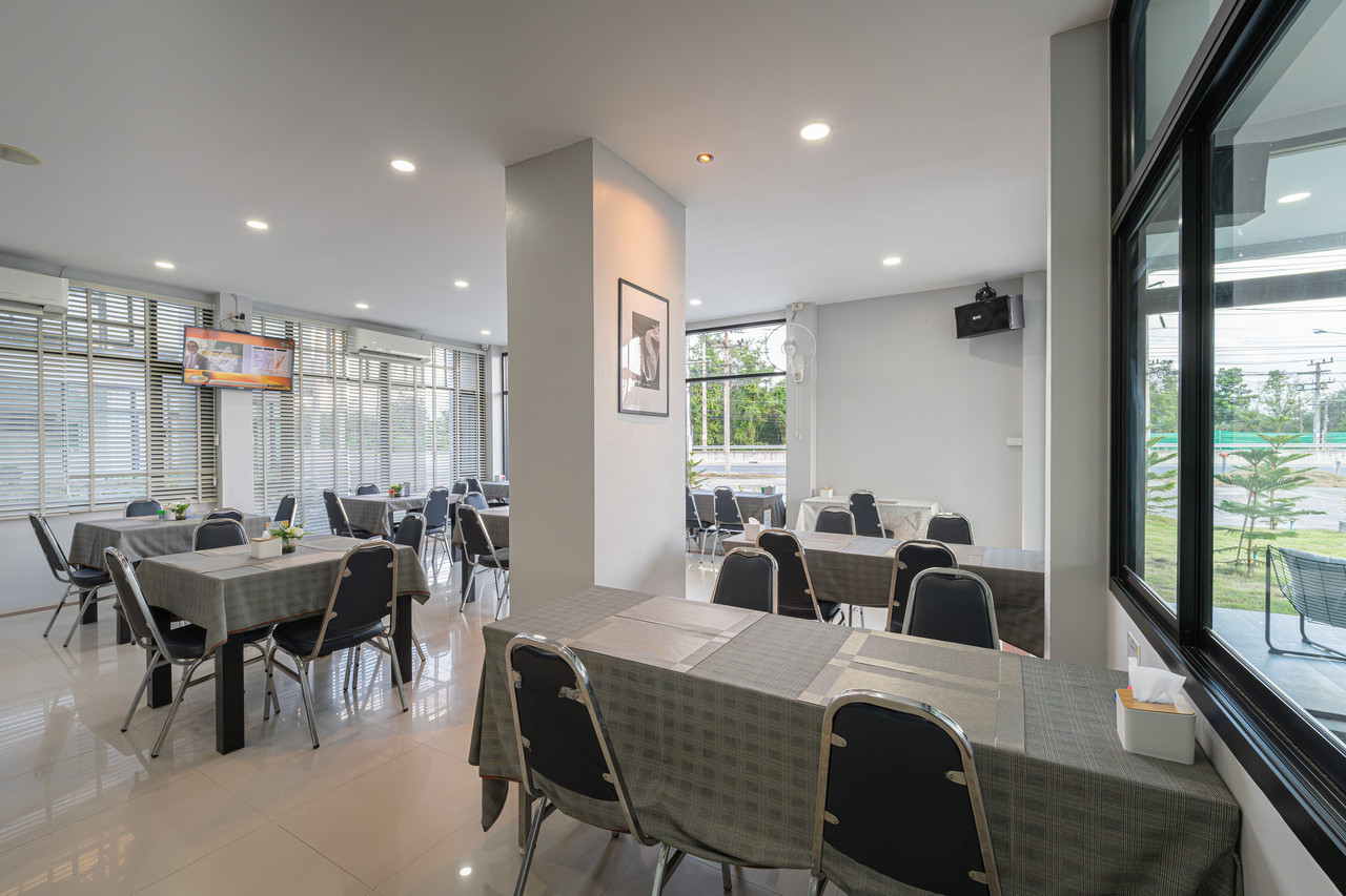 ห้องอาหารเช้าของ C2U Hotel Uthai Thani โต๊ะผ้าลายสก๊อต กระจกบานใหญ่มองเห็นถนน