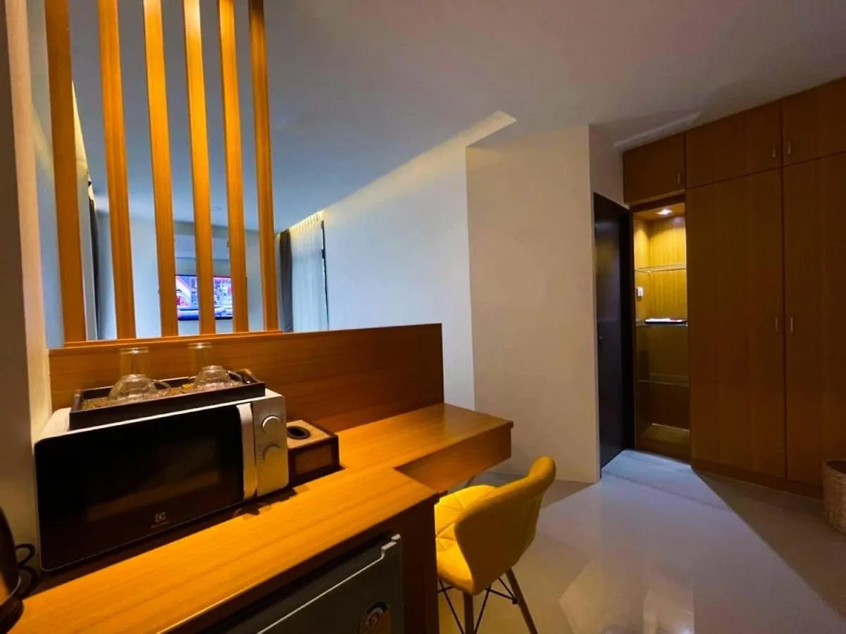 Wooden work desk in the room with microwave, tea and coffee set, and wardrobe