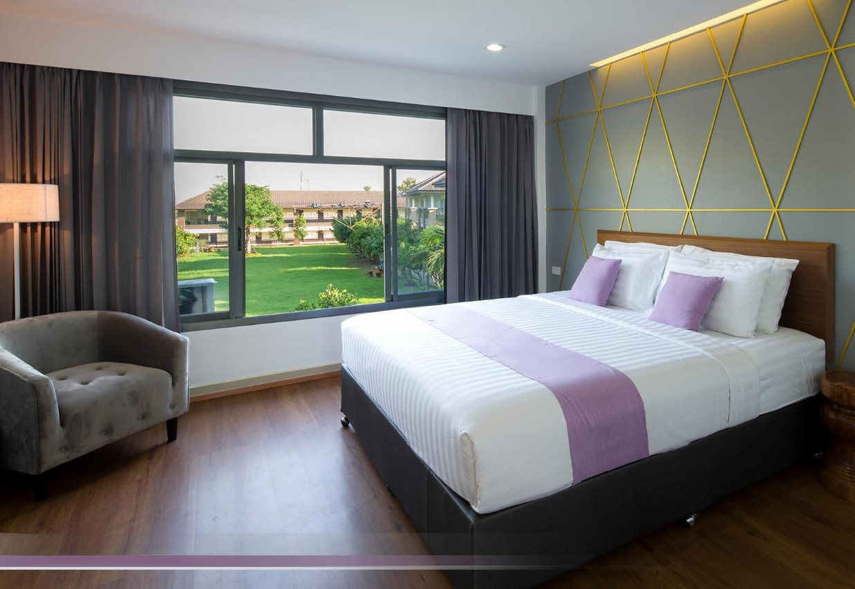 Araya Hotel villa guest room with king bed and green garden view