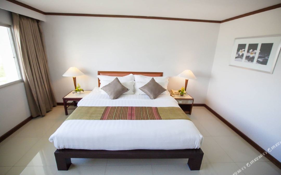 King-bed room at Friday Hotel Uttaradit with a Thai-textile bed runner