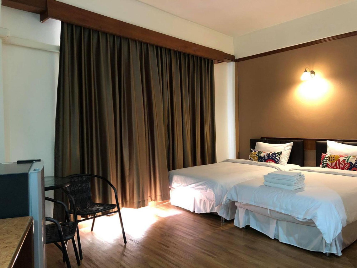 ห้องเตียงแฝดสองเตียง ผ้าม่านสีน้ำตาล หมอนลายดอก Betong Hill Residence