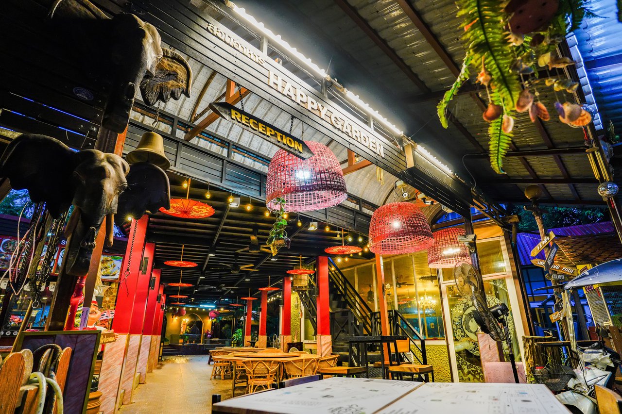 Bohemian-styled reception and restaurant area with the Happy Garden Resort sign
