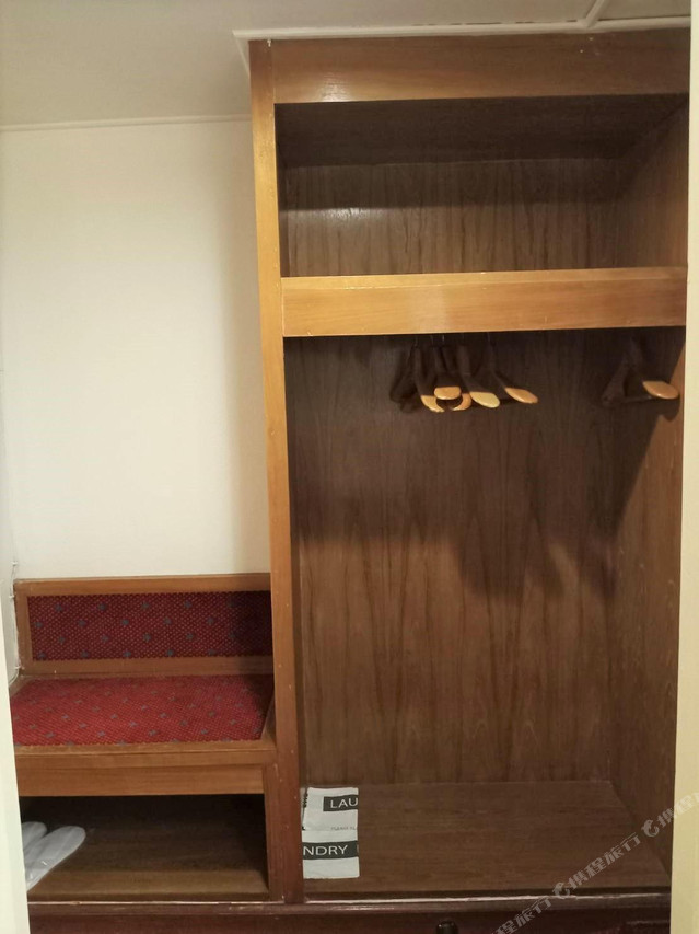 ตู้เสื้อผ้าไม้และชั้นวางในห้องพัก The New Cathay Hotel Betong