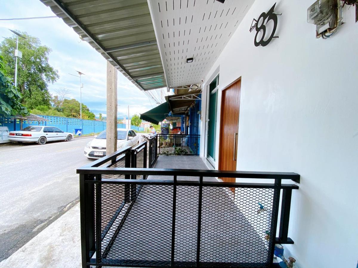 Guesthouse balcony looking onto a central Betong street with hills in the distance and the 'the 83' logo on the wall