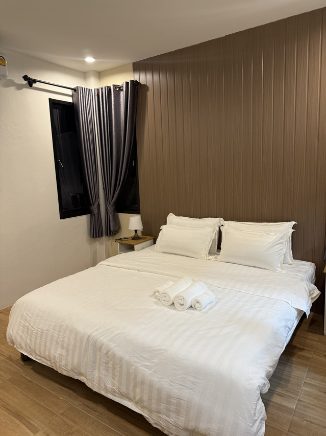 Garden Room with a King bed, warm wood-panel wall and grey curtains for a quiet, cosy feel