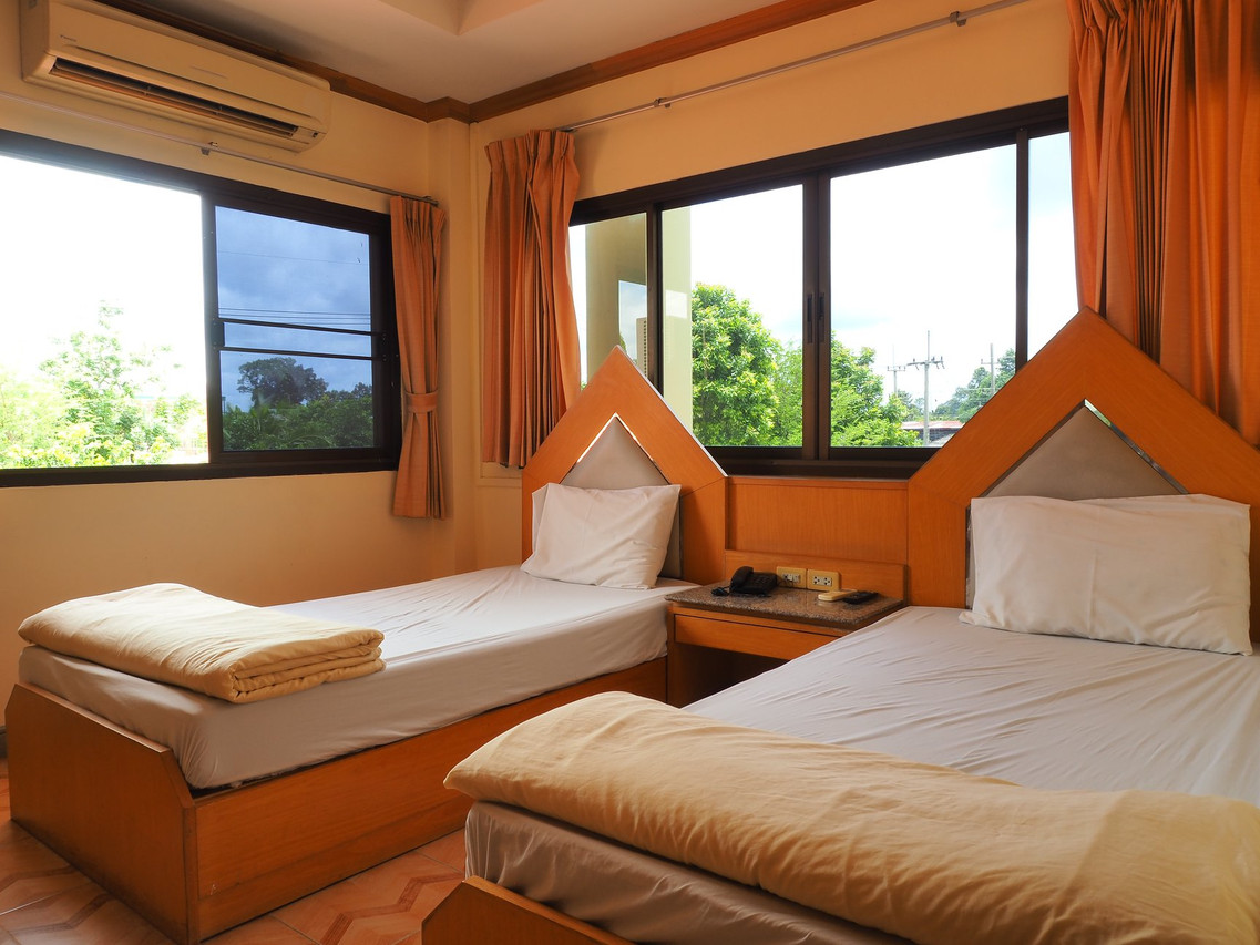 ห้อง Standard Twin เตียงเดี่ยวสองเตียง หัวเตียงไม้ทรงสามเหลี่ยม ม่านสีส้ม Crystal Hotel Yasothon ยโสธร