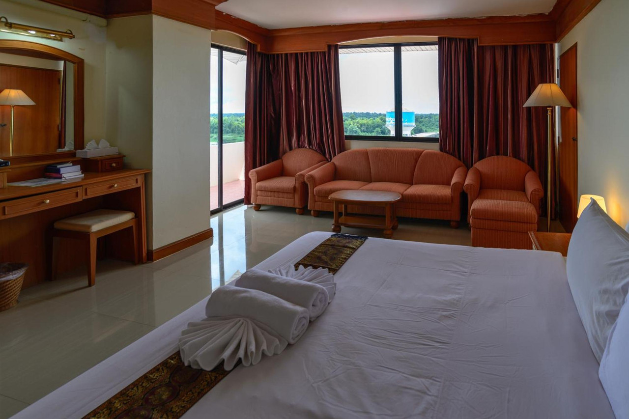 ห้องพักขนาดใหญ่ของ JP Emerald Hotel มีโซฟารับแขกและวิวเมืองยโสธร