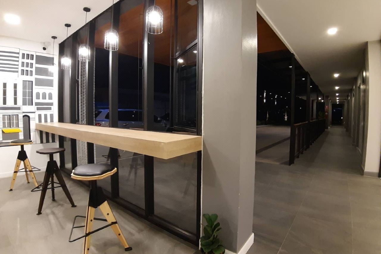 Wood-counter lounge nook by the glass with hanging lights and an interior walkway