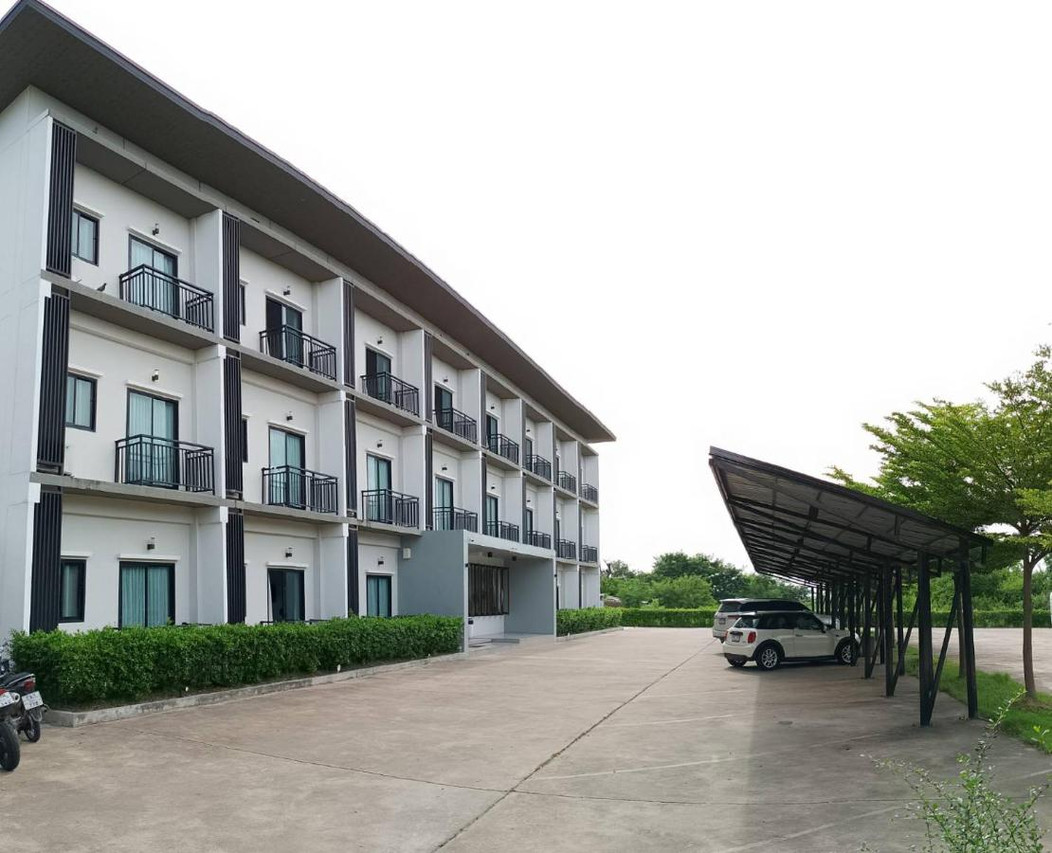 The white three-storey Zen Hotel Yasothon from the side, with a covered car park