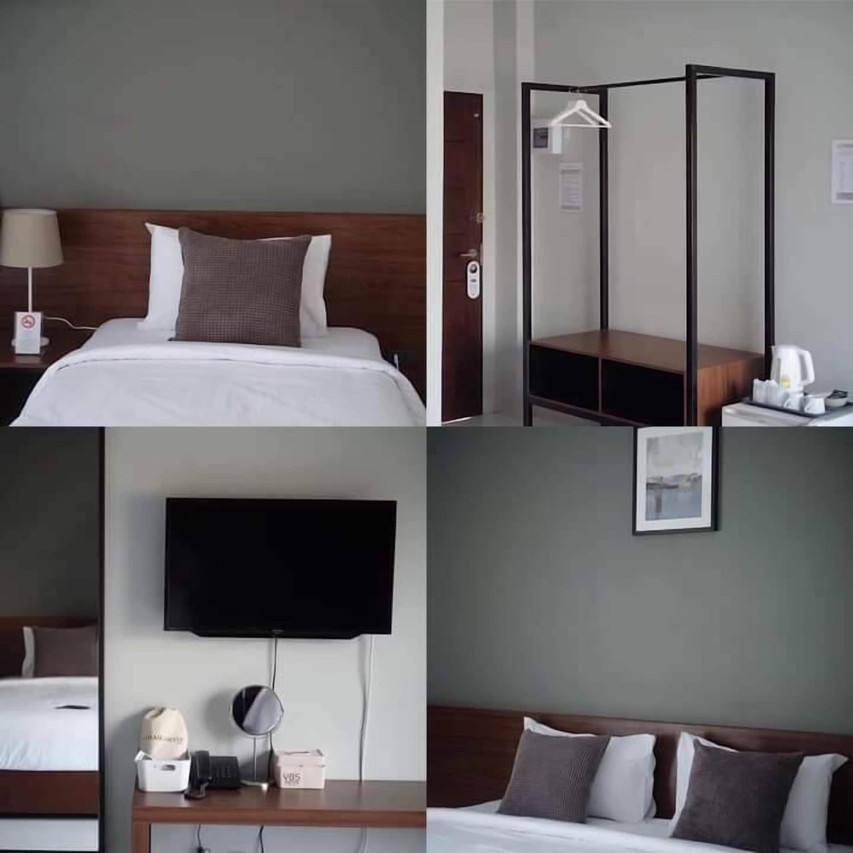 Room corner showing a flat-screen TV, open hanging wardrobe and a small drinks station
