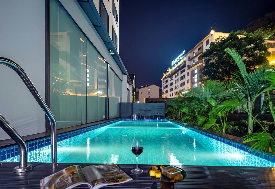 สระว่ายน้ำของ Zhangjiajie Yujie Hotel ตอนกลางคืน มีตึกโรงแรมเป็นฉากหลัง